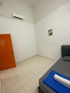a small room with a bed and a door at Bertam Transit Homestay in Kampong Alor