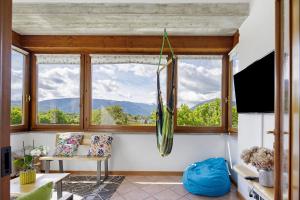 a living room with a large window with a view at La Veranda - Alpago in Pieve dʼAlpago +26 photos