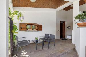 a patio with chairs and a table and a window at La Veranda - Alpago in Pieve dʼAlpago