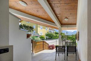 a patio with a wooden ceiling and a table and chairs at La Veranda - Alpago in Pieve dʼAlpago