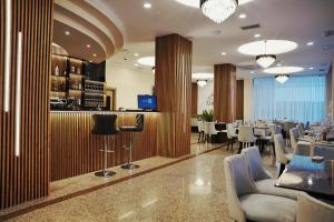 a restaurant with a bar with tables and chairs at Lumera Hotel in Durrës