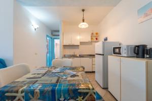 a kitchen with a table and a refrigerator at Raffy by DomusAway in Porto San Paolo