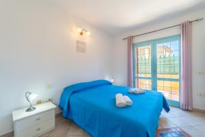 a bedroom with a blue bed and a window at Raffy by DomusAway in Porto San Paolo