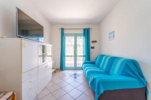 a living room with a blue couch and a tv at Raffy by DomusAway in Porto San Paolo