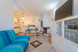 a living room with a blue couch and a kitchen at Raffy by DomusAway in Porto San Paolo +9 photos