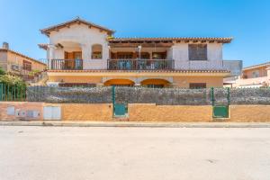 a house with a fence in front of a building at Raffy by DomusAway in Porto San Paolo