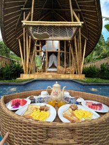 a table with plates of food on top at Bamboo Garden Villa Sidemen - Private Pool & Nature View in Selat