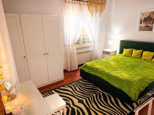 a bedroom with a green bed and a zebra rug at Villa SOLE di AMORE - POOL PRIVATE LARGE 100 M 2 - Beach 950m -Center 500 m - ROME & AIRPORT 39 km in Anzio