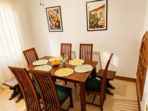 a dining room with a wooden table and chairs at Villa SOLE di AMORE - POOL PRIVATE LARGE 100 M 2 - Beach 950m -Center 500 m - ROME & AIRPORT 39 km in Anzio