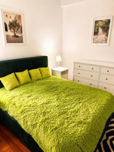 a bedroom with a green bed with yellow pillows at Villa SOLE di AMORE - POOL PRIVATE LARGE 100 M 2 - Beach 950m -Center 500 m - ROME & AIRPORT 39 km in Anzio