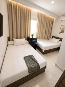 a bedroom with two beds and a window at vila hotel city in Cairo