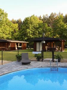 a swimming pool in a yard with a house at Leśny Azyl in Zwierzyniec