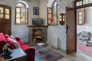 a living room with a fireplace and a red couch at Casale Panayiotis in Kalopanayiotis