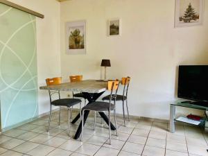 a dining room table with chairs and a television at Waldesruh RE12 in Sögel +25 photos
