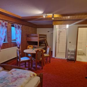 a room with a table and a bed and a bathroom at Gästehaus Bettina in Sipplingen