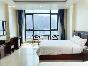a hotel room with a bed and a large window at Song Nga Boutique Hotel Cat Ba in Cat Ba