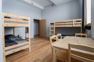 ein Zimmer mit zwei Etagenbetten und einem Tisch in der Unterkunft Purva3 in Valmiera