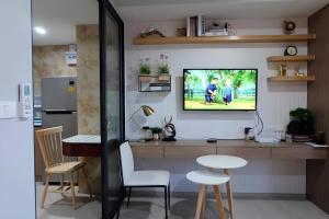 a living room with a tv on a wall at Exclusive Condo with Pool - Self Check-in in Hua Hin