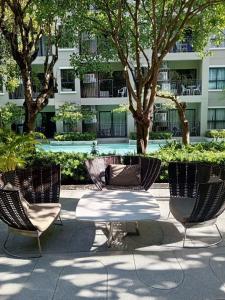 a group of chairs and a table in front of a building at Exclusive Condo with Pool - Self Check-in in Hua Hin
