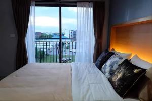 a bedroom with a bed and a large window at Exclusive Condo with Pool - Self Check-in in Hua Hin +37 photos