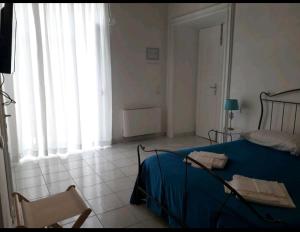 a bedroom with a bed and a chair and a window at Residenza d'epoca Olimpia in Santa Maria di Castellabate