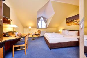 a bedroom with a bed and a desk and a table at Hotel Linderhof in Erfurt +59 photos