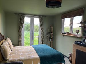 a bedroom with a bed and two windows at Digital detox unplugged retreat in Southam