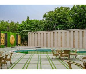 a pool with tables and chairs next to a building at Sagar Resort in Alwar