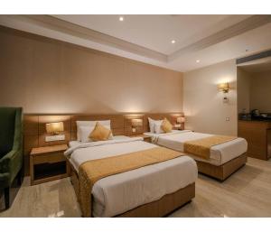 a hotel room with two beds and a chair at Sagar Resort in Alwar +54 photos
