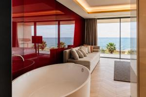 a bathroom with a tub and a couch and a bedroom at Hotel Villa Pascucci Mare in Durrës