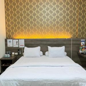 a bedroom with a large bed with white pillows at Hotel Grand Ansara Mentari in Baturaja