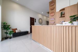 a lobby with a wooden wall and a reception counter at Cove Amayana in Surabaya