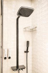 a shower with a shower head in a bathroom at Ace Stayz - Boutique Hotel Near DLF Mall Sector 45, Noida in Noida