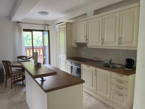 a kitchen with white cabinets and a sink and a table at Villa Nona with swimming pool in Dornberk