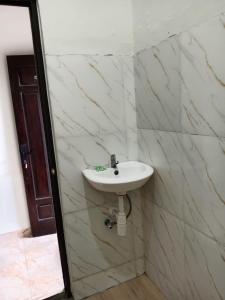 a white sink in a bathroom with marble walls at Hotel Grand Ansara Mentari in Baturaja +22 photos