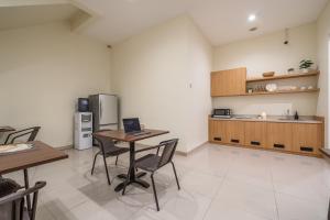 a kitchen with a table and chairs and a refrigerator at Cove Amayana in Surabaya +41 photos