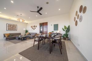 a dining room and living room with a table and chairs at Cove Amayana in Surabaya