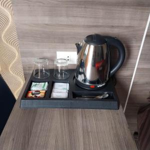 a tea kettle on a tray on a table at Hotel Grand Ansara Mentari in Baturaja