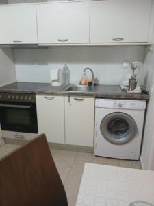 a kitchen with a sink and a washing machine at Πόλη της Κέρκυρας διαμέρισμα in Corfu