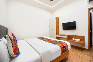 a white bedroom with a bed and a tv at FabHotel A Square - 400m from Bhimavaram Junction in Bhīmavaram