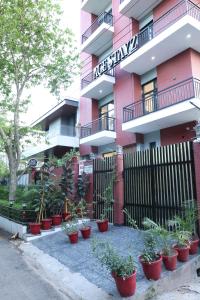 a row of potted plants in front of a pink building at Ace Stayz - Boutique Hotel Near DLF Mall Sector 45, Noida in Noida
