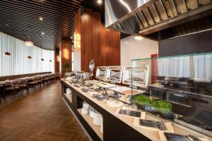 a restaurant with a long counter with plates of food at ZUMMA Hotel Almaty in Almaty