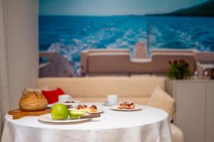 a table with two plates of food on it at Captain's Escape - Spa City View in Mali Lošinj