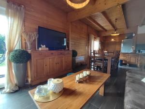 a living room with a table and a tv at Le Châlet Nature de Lieurey in Lieurey