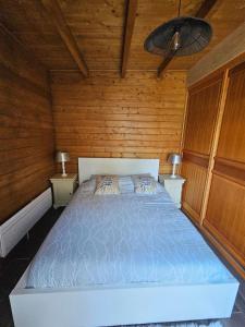 a bedroom with a bed in a wooden room at Le Châlet Nature de Lieurey in Lieurey