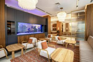 a waiting room at a hotel with tables and chairs at ZUMMA Hotel Almaty in Almaty