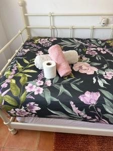 a bed with a floral bedspread and two rolls of toilet paper at Mex-Goretti House in Mairena del Aljarafe +47 photos