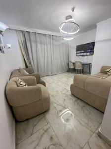 a living room with two couches and a table at اهرمات بورتو السخنه in Madinaty