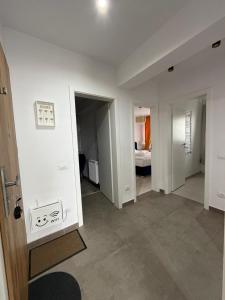 a room with white walls and a hallway with a bedroom at Elite Noua in Braşov