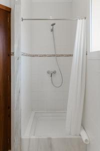 a shower with a shower curtain in a bathroom at Hostal Palmaria in Cala Santanyi +72 photos